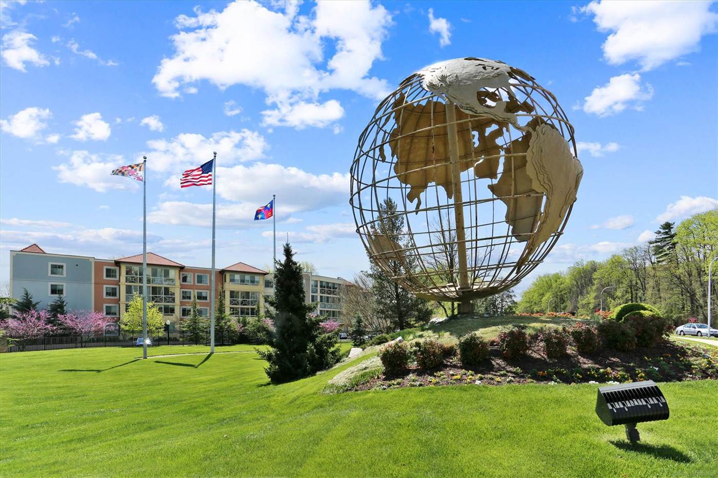 Leisure World globe sculpture with flags and residential buildings